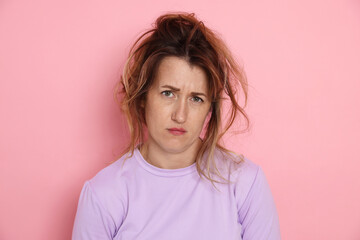 Woman suffering from hangover on pink background