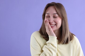 Attractive woman laughing on violet background. Space for text