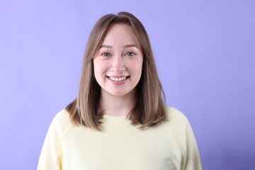 Attractive woman laughing on violet background. Positive emotion