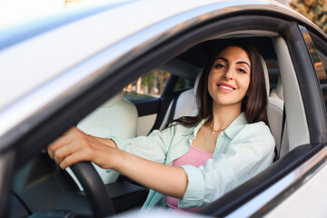 Woman holding steering wheel while driving car, view from outside