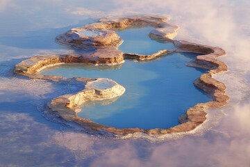 Aerial view of a geothermal landscape. Pools of turquoise water within eroded earth formations