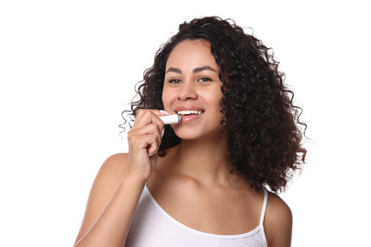 Smiling woman applying lip balm onto her lips on white background - Powered by Adobe
