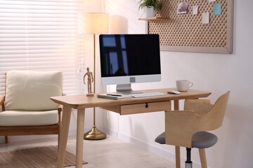 Stylish workplace with wooden desk, computer and stationery at home office. Interior design