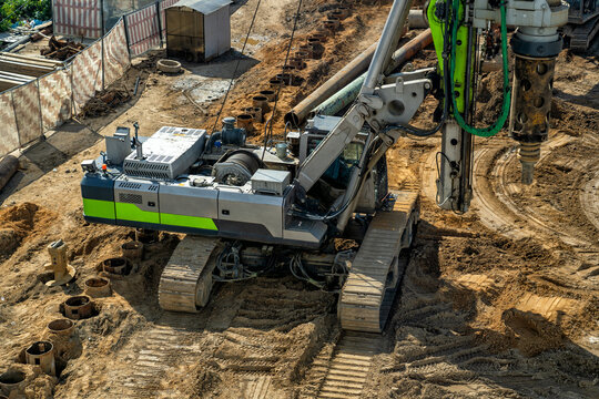 Powerful crawler drilling rig in operation, excavating deep holes for building foundations on large construction site