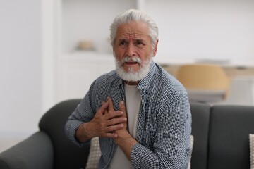 Senior man suffering from chest pain at home