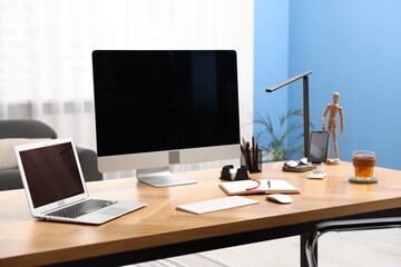 Stylish workplace with modern computer, other devices and stationery on wooden desk indoors
