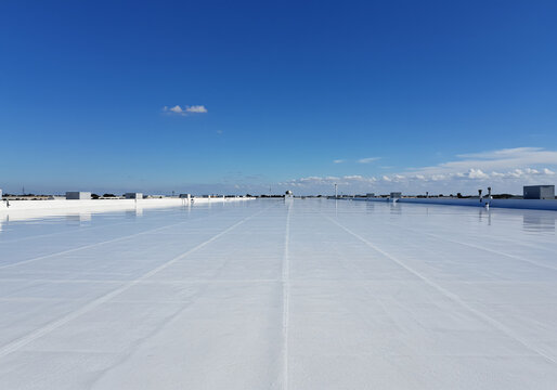 White Reflective Industrial Building Roof Surface Under Blue Sky Heatwave
