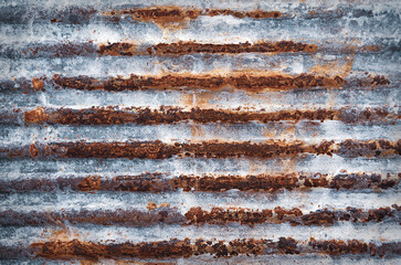 Background of industrial material. Grunge texture.
Rust on corrugated metal. Aged steel surface with rust streaks.