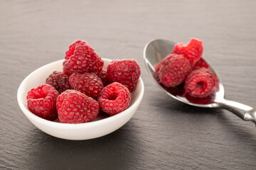 Sweet ripe raspberries on slate stone, macro,.