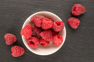 Sweet ripe raspberries on slate stone, macro, top view.