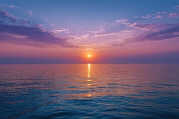Obraz premium Vibrant sunset over calm ocean waters reflecting golden hues of the setting sun