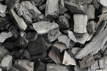 Pieces of black coals as background, top view