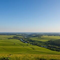 Obraz premium Breathtaking high-angle view of a serene river valley with rolling green countryside under a clear blue sky.