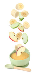 Baby food. Apple and banana slices falling into bowl of puree on white background