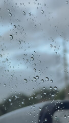 Water droplets clinging to a car window, creating a soft, moody atmosphere after rainfall