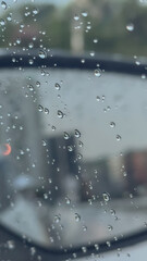 Water droplets clinging to a car window, creating a soft, moody atmosphere after rainfall