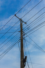 A powerful image of tangled power lines against a clear blue sky, showing the complexity of modern infrastructure