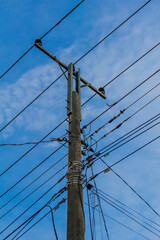 A powerful image of tangled power lines against a clear blue sky, showing the complexity of modern infrastructure
