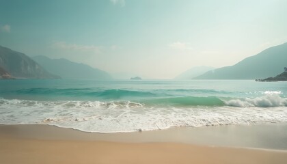 Soft waves break on sandy beach under hazy sky with distant mountains. Teal ocean water offers serene, tropical atmosphere perfect for vacation travel themes. Gentle surf creates peaceful, relaxing