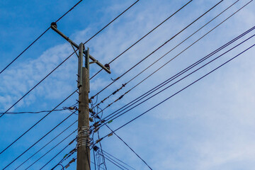 A powerful image of tangled power lines against a clear blue sky, showing the complexity of modern...