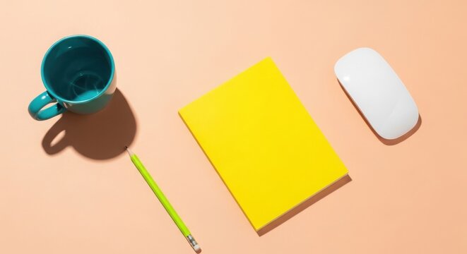 Teal mug yellow notebook green pencil and white computer mouse on peach background image