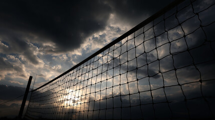 Volleyball net silhouette against dramatic cloudy sky at dusk, bold contrast