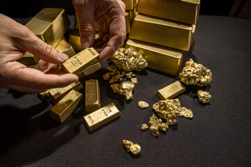 Male hands holding Bank gold bars, Gold Nuggets. Gold reserv holdings concept. Savings and...