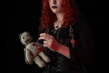 Witch wizard witchcrafting, performing ritual with handmade voodoo doll. Young woman, a magician...
