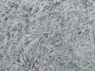 Close-up macro of sharp ice crystals on a frozen surface