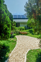 Solar panel on a roof reflecting the sun and blue sky,photovoltaic panels on the roof,Roof Of solar cell with sunlight and view small garden in forest.