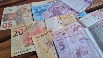 Brazilian real notes superimposed on a wooden background