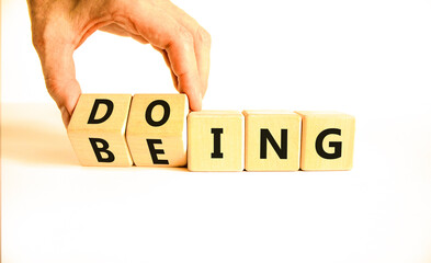 Doing or being symbol. Concept word Doing and Being on wooden cubes. Businessman hand. Beautiful...