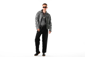 Handsome young man wearing stylish jacket and sunglasses on white background