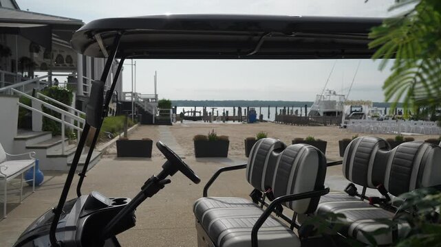 A stylish electric golf cart is parked by the scenic waterfront, ideal for resorts and relaxing leisure areas
