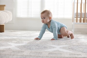 Cute little baby crawling on floor at home, space for text