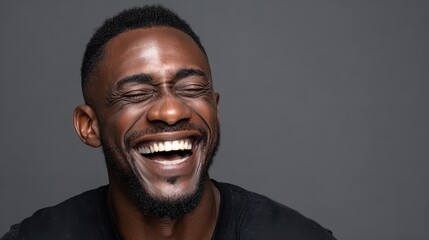 Obraz premium handsome unshaven young darkskinned male laughing out loud at funny meme he found on internet smiling broadly showing his white straight teeth positive human facial expressions and emotions no logos 