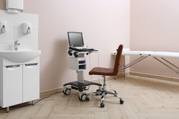 Modern ultrasound machine, chair and examination bed in clinic