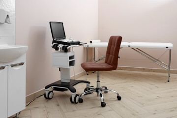 Modern ultrasound machine, chair and examination bed in clinic