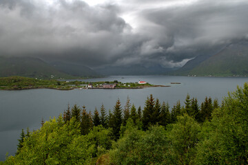 Rural Landscape With Remote Village, Calm Fjord And Foggy Mountains On Lofoten Islands In Norway