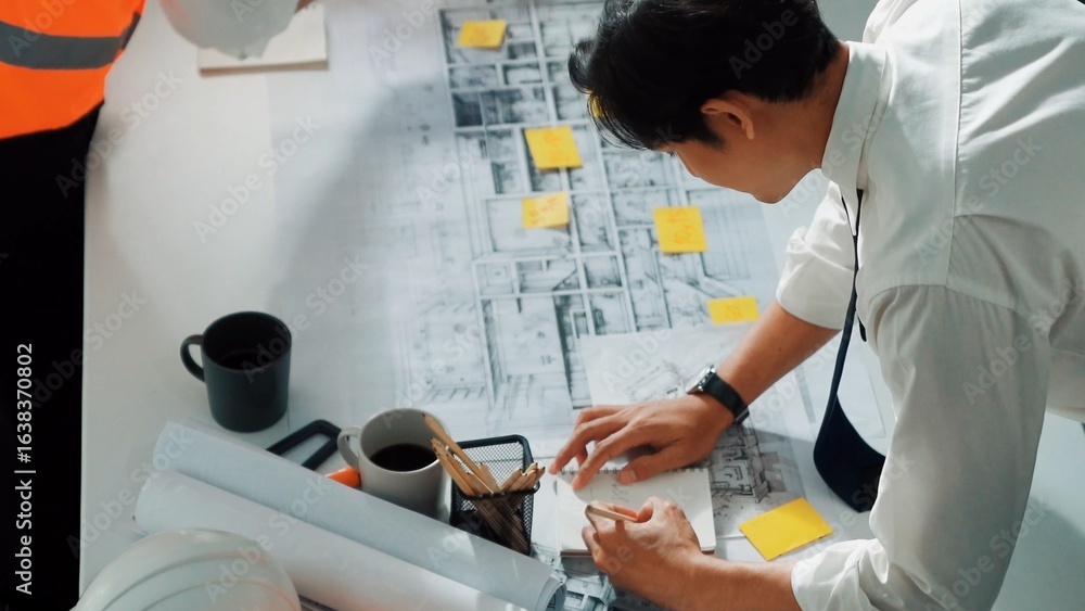 Poster top view of professional architect engineer team inspect house model while manager holding blueprint