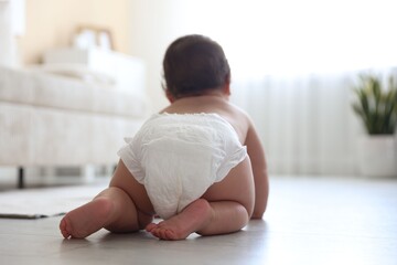Cute little baby crawling on floor at home, back view