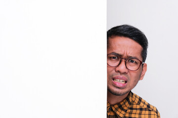 A man face peeking from behind a wall showing scared face expression