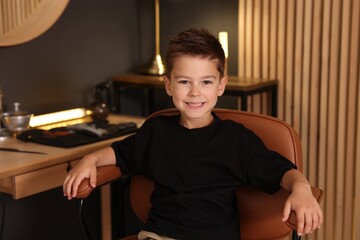 Portrait of cute little boy in barbershop