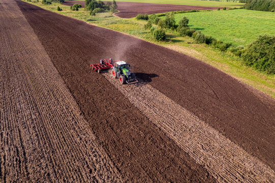tractor cultivating a field with a harrow