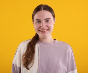 Beautiful woman laughing on yellow background. Positive emotion