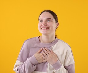 Beautiful woman laughing on yellow background. Positive emotion