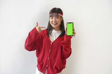 Cheerful Indonesian woman wearing a red sweater and white T-shirt shows a photocopying space on her...