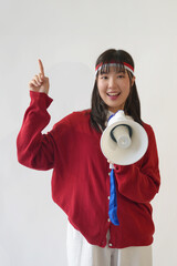 Attractive young Asian woman holding a megaphone and raise a clenched fist hand gesture. Indonesia...