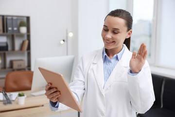 Fototapeta premium Doctor with tablet having online consultation in clinic