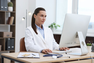 Doctor having online consultation via computer in clinic